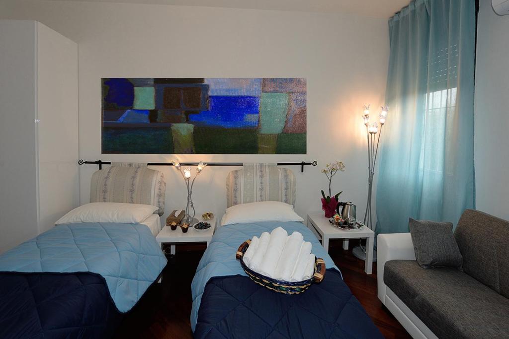 uma sala de estar com duas camas e um sofá em Tintoretto Inn B&B em Roma