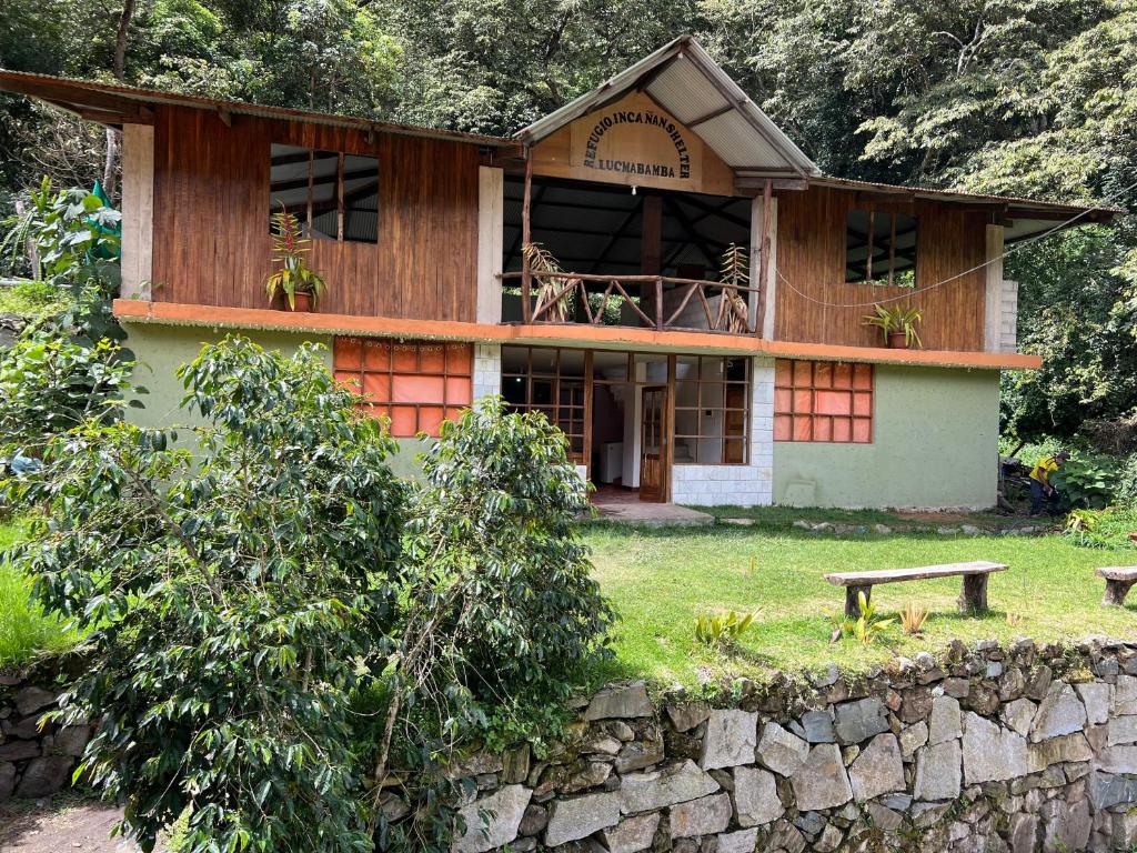 a house with a bench in front of it at Eco Inca Trail Lodge Lucmabamba in Cusco