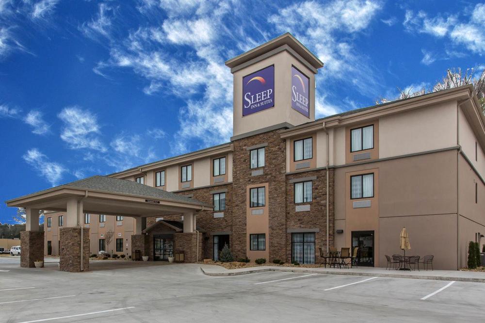 a hotel with a sign on the top of it at Sleep Inn & Suites Dayton in Dayton