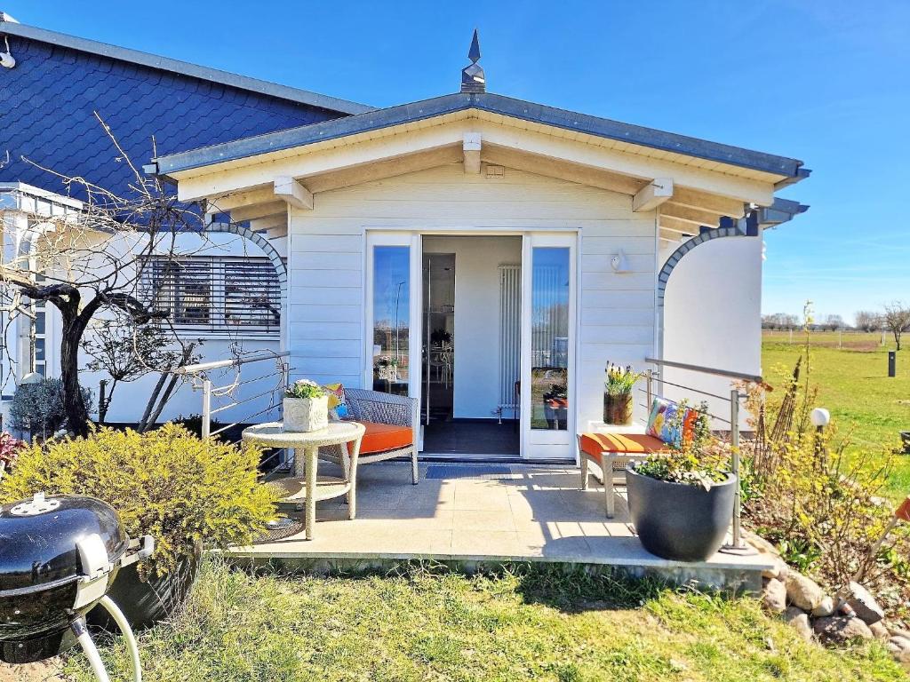 a small white house with a porch and a door at Küstenliebe in Stove Ostsee, exklusiv - ABC584 - nur Ferieng in Boiensdorf
