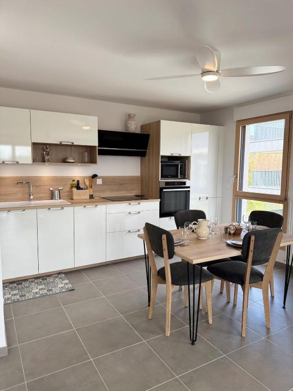 une cuisine et une salle à manger avec une table et des chaises dans l'établissement Le Doublaix - Superbe T3 neuf - Parking privé -, à Aix-les-Bains