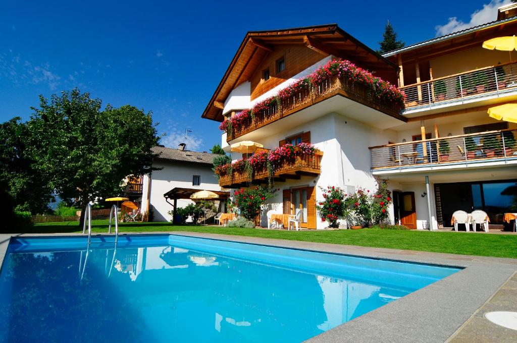 a house with a swimming pool in front of a house at Haus Rosengarten in Tirolo