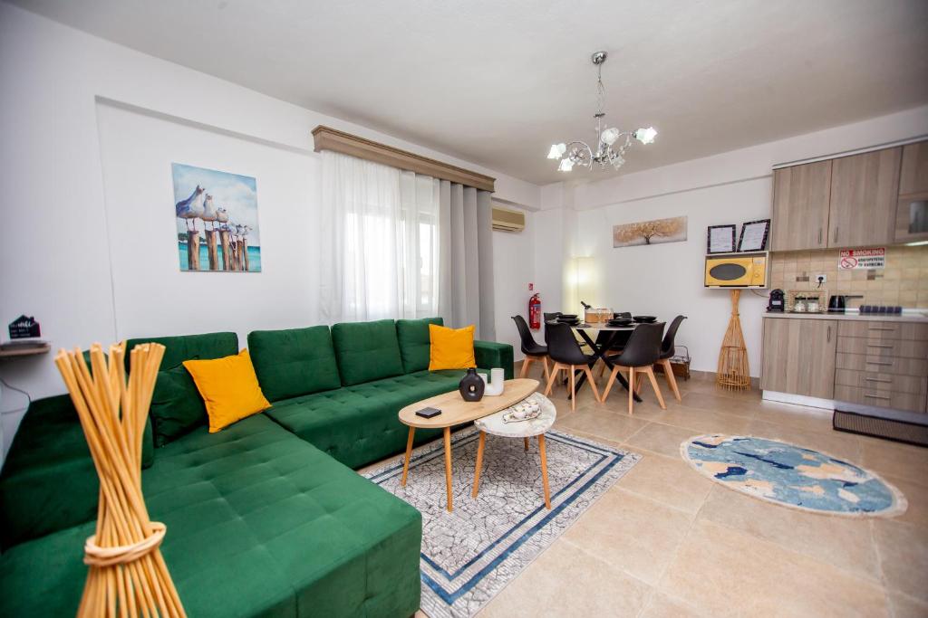 a living room with a green couch and a table at LUNA'S HOUSE in Asprovalta