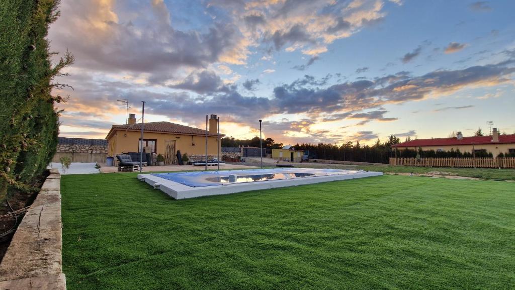 a backyard with a pool in the middle of a grass field at La finca de Casa Botes in Cuenca