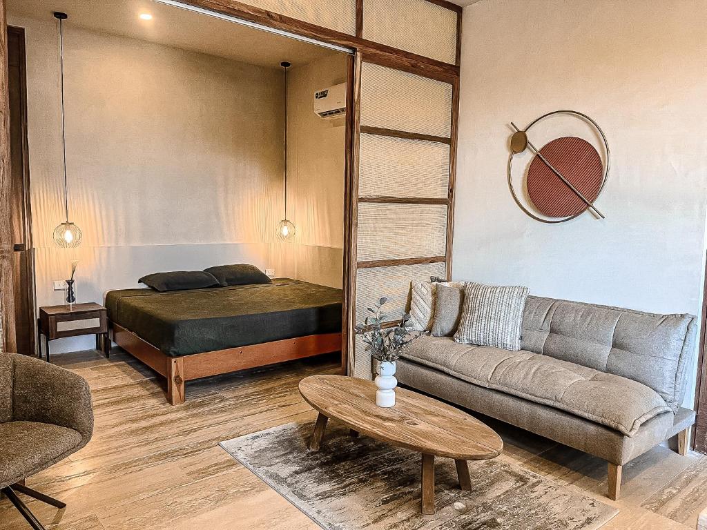 un salon avec un canapé et un lit dans l'établissement Departamento 304 by Rotamundos, à Playa del Carmen