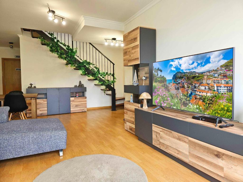 a living room with a large flat screen tv at A SELVA T2 in Caniço in Caniço