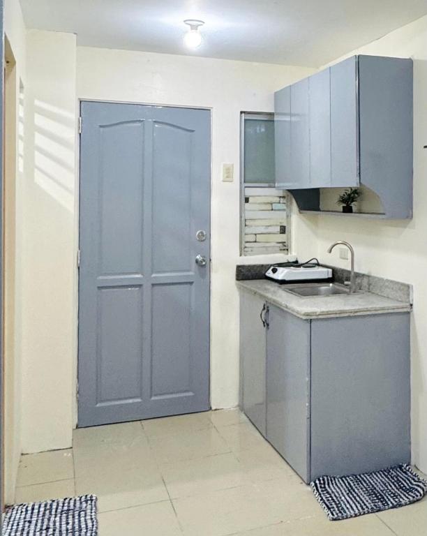 a kitchen with a blue door and a counter top at ACE Condo in Cebu City