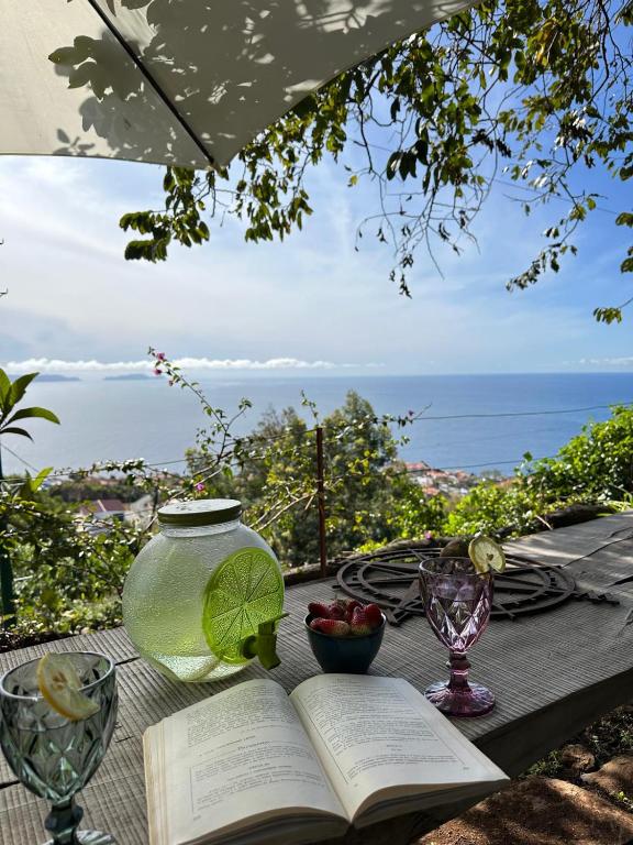 Ein offenes Buch liegt auf einem Tisch mit Blick auf das Meer in der Unterkunft Casa de basalto in Caniço