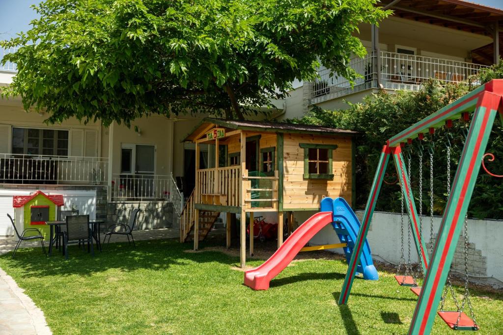 un patio de juegos con un parque infantil con una casa en Elenas House, en Nea Kalikratia