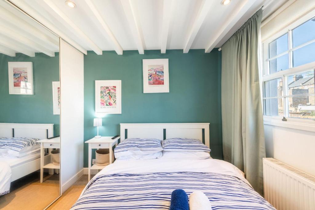 a bedroom with a bed and a blue wall at Stylish flat in West Hampstead in London