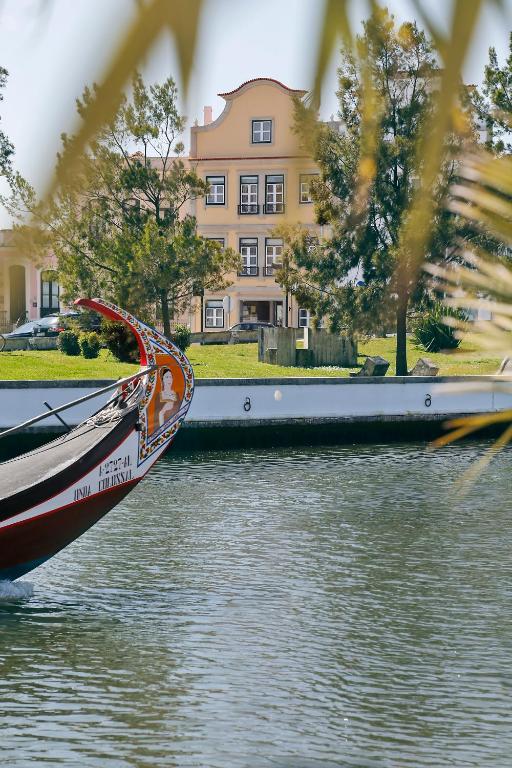 una barca in acqua davanti a un edificio di Hotel das Salinas by Alboi Group ad Aveiro
