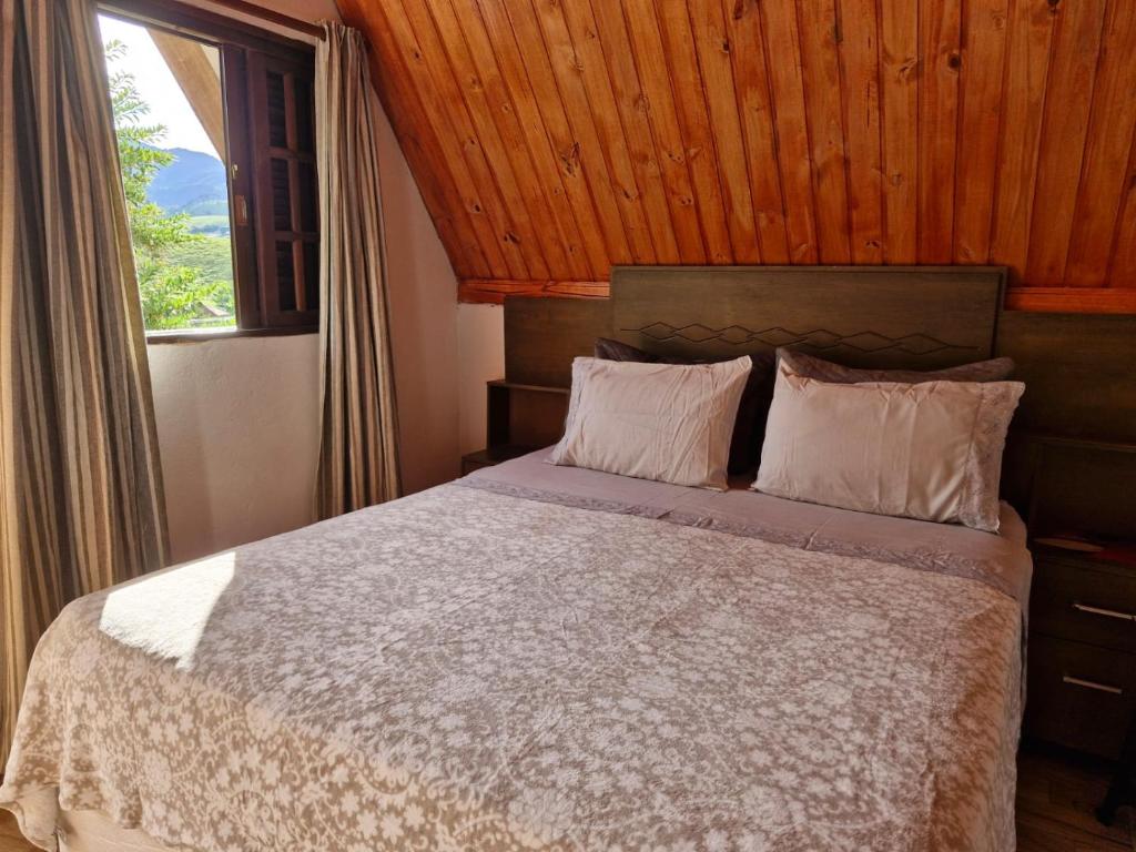 Ένα ή περισσότερα κρεβάτια σε δωμάτιο στο Chalés São Bento Sapucaí 5 minutos centro 20 minutos cachoeiras e 30 minutos pedra do baú