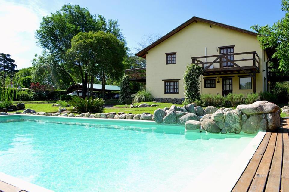 una gran piscina frente a una casa en la matilda en Santa Rosa de Calamuchita