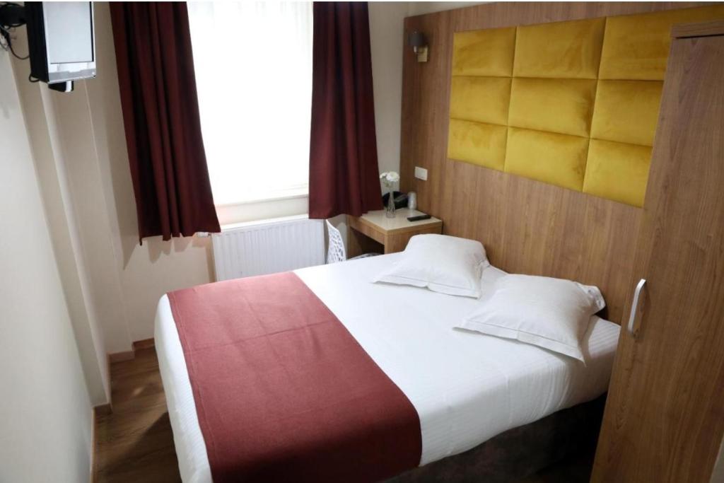 a bedroom with a large bed with a red and white blanket at Hotel Boutique Patricia in Tirana