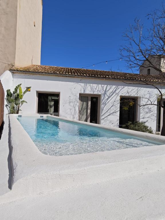 a swimming pool in front of a white house at Ático loft en molino antiguo in Paterna