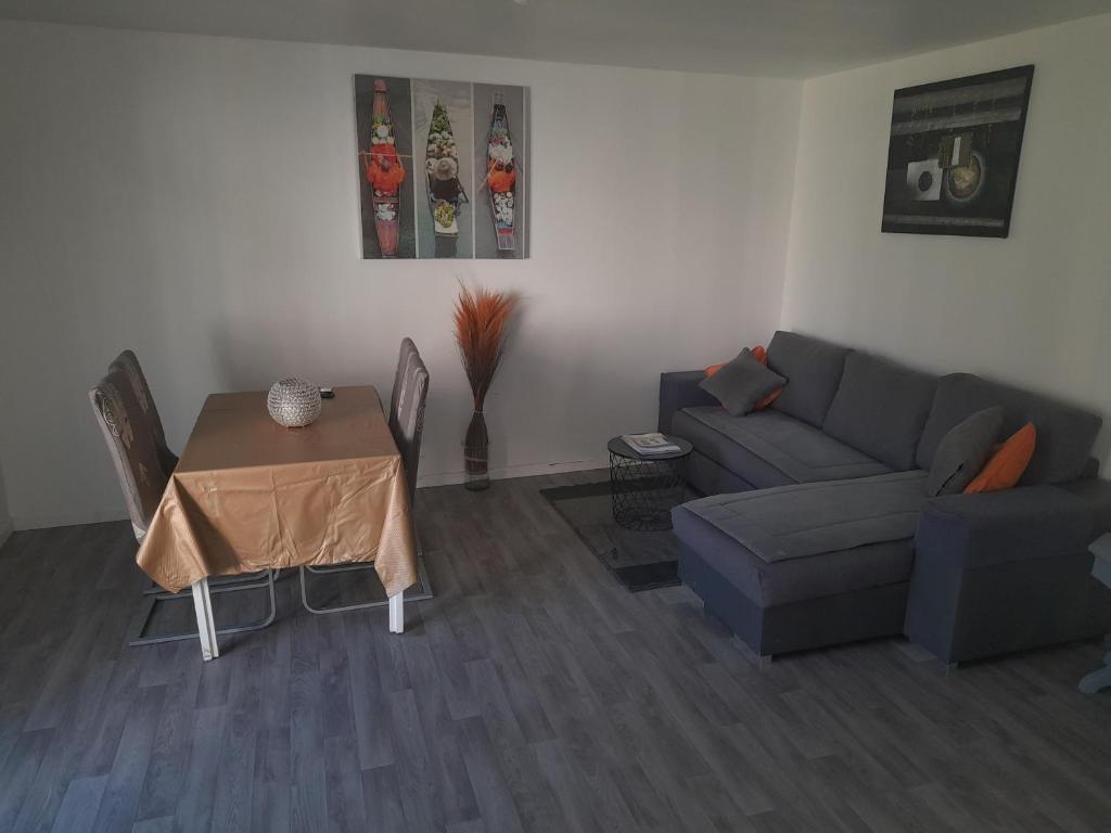 un soggiorno con un divano e un tavolo di Family House a Beauvais
