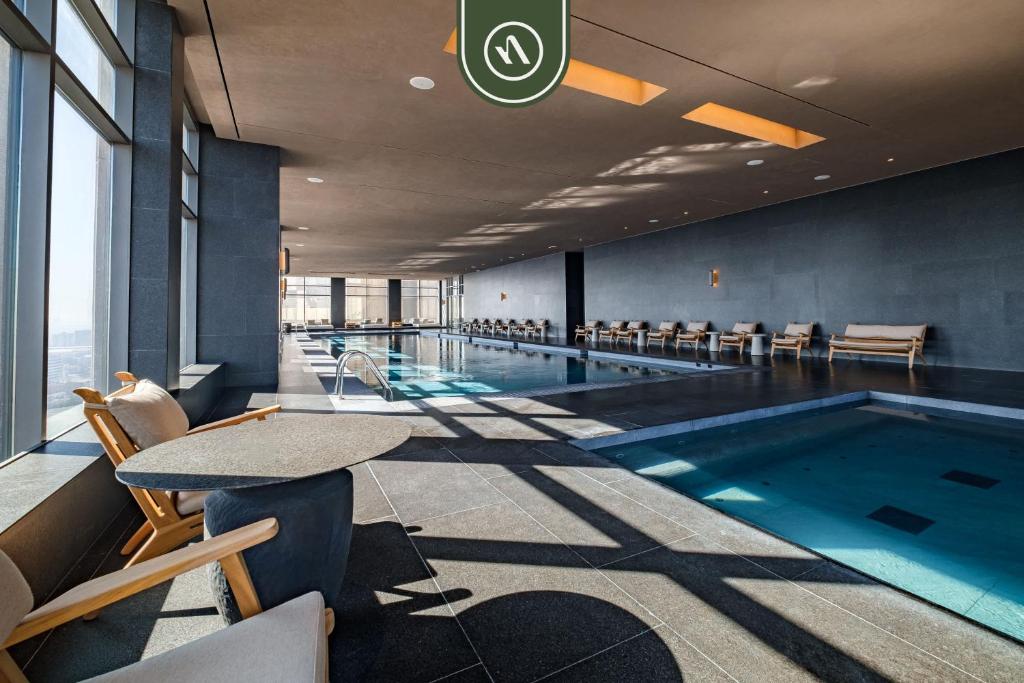 una gran piscina con mesa, sillas y mesa en Luxury 2 BR Condo - Amazing City View - Pool - Gym, en Ciudad de México