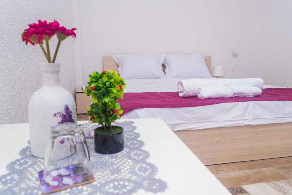 Un dormitorio con una cama y una mesa con flores. en Bed & Breakfast Delikates, en Stojakovo