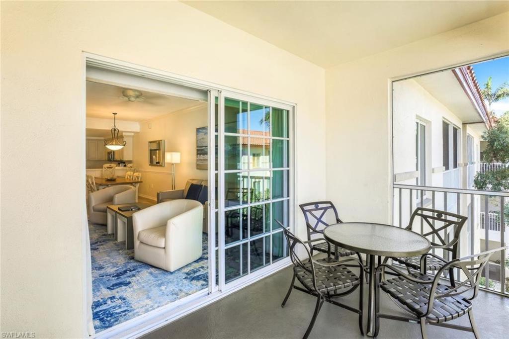 a room with a balcony with a table and chairs at Bellasera Resort in Naples