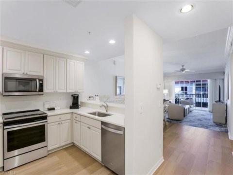 a white kitchen with a sink and a stove at Bellasera Resort in Naples