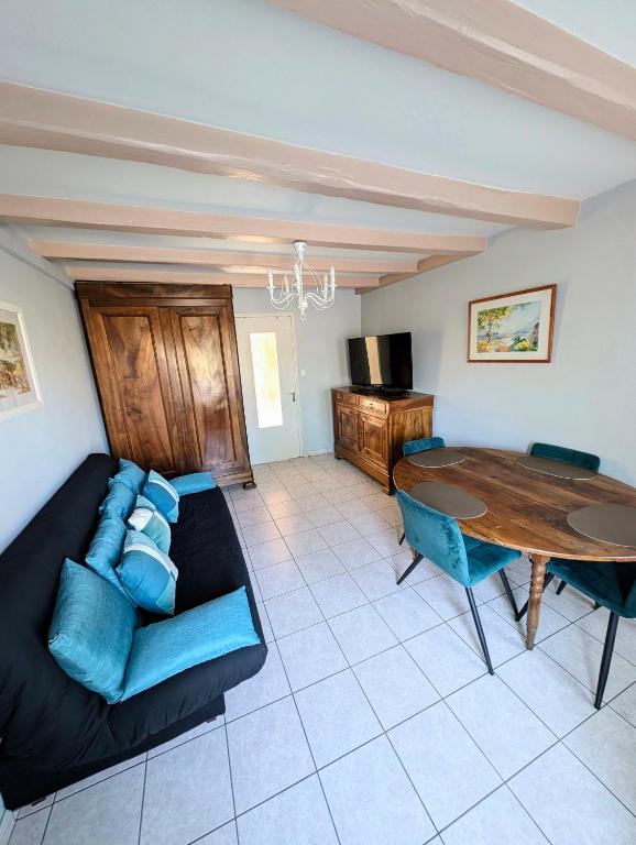 un salon avec un canapé et une table dans l'établissement Maison de village classé petite cité de caractère, à Foussais