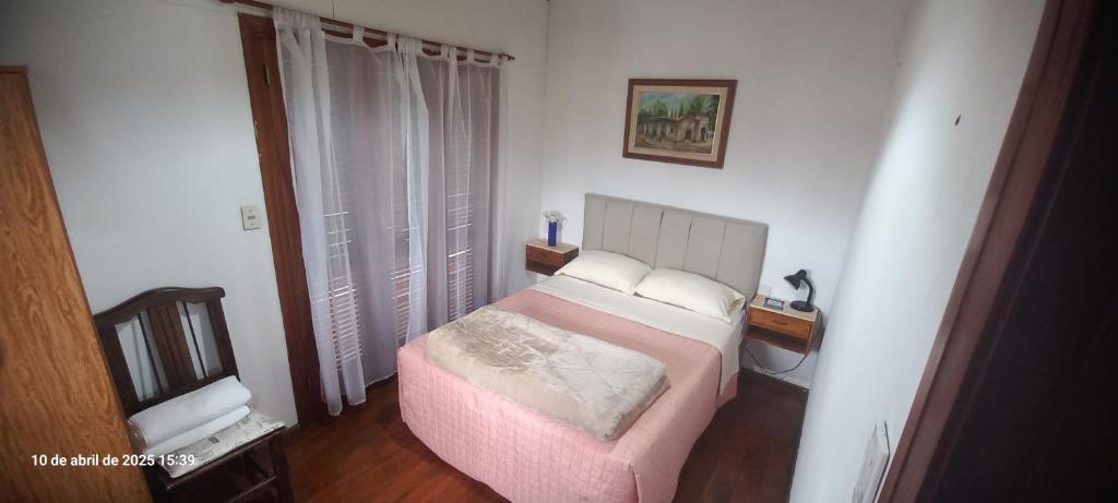 a bedroom with a bed with a pink bedspread at VICTORIA 2 bed and breakfast departamento in Ezeiza