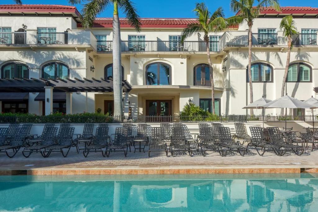 a hotel with chairs and a swimming pool in front of a building at Bellasera Resort in Naples