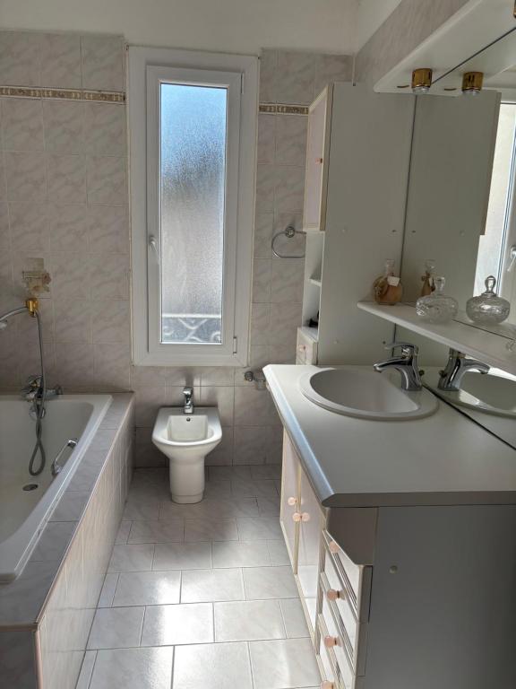 une salle de bain avec une baignoire, un lavabo et des toilettes dans l'établissement Pietralba t3, à Ajaccio