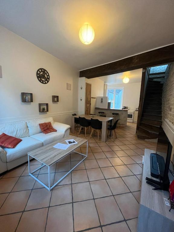 a living room with a white couch and a table at Le gîte nivernais in Varzy