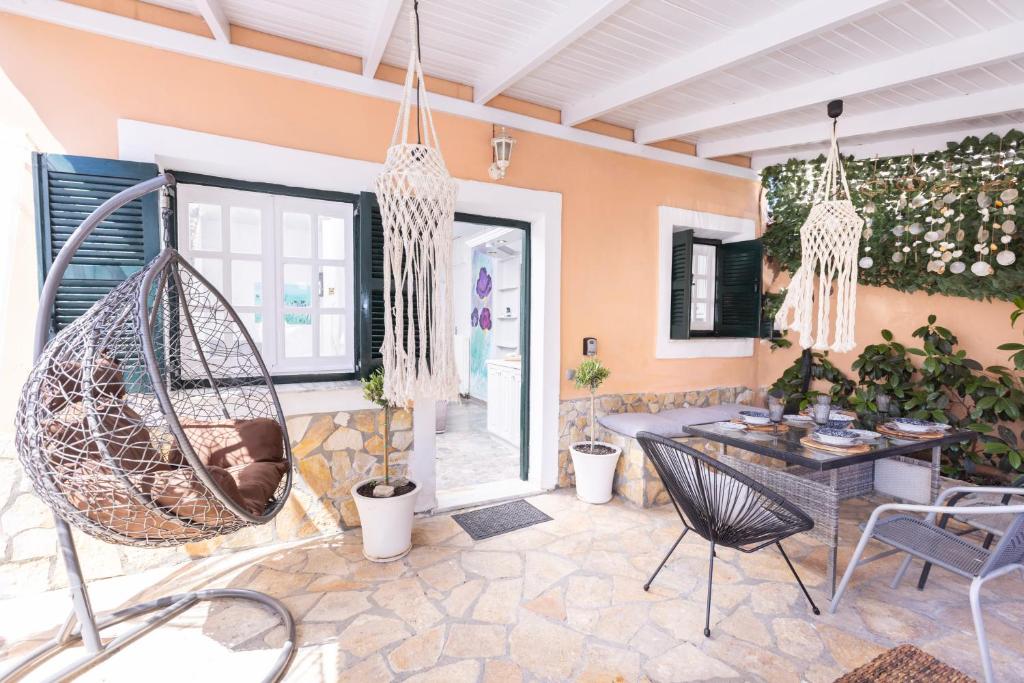 a patio with a swing and a table and chairs at A flower house in Mantoúkion