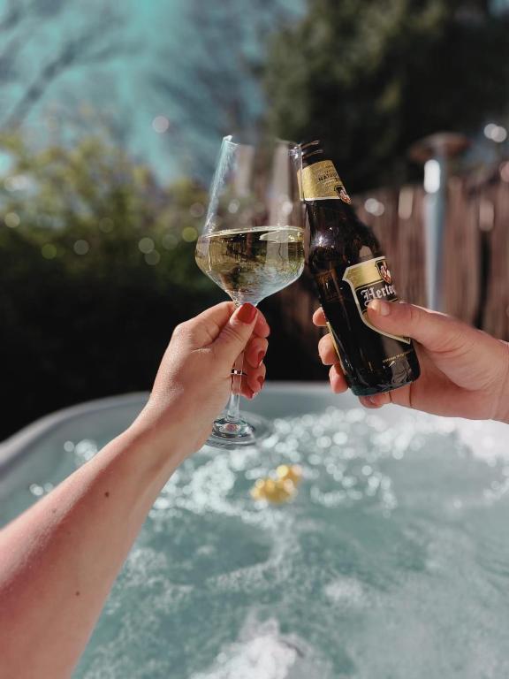 two people holding up a glass of wine at HottuB - Wellnesshuisje - Bos - Oudveluwe in Voorthuizen