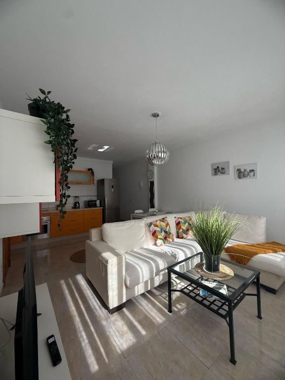 a living room with a white couch and a table at Casa Velalatina in La Santa