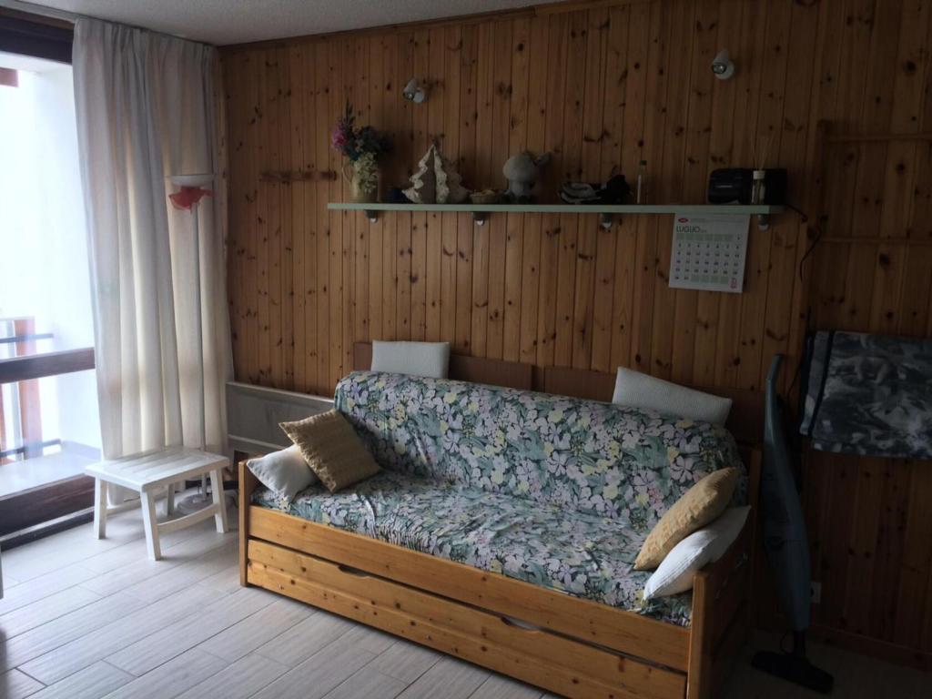 - un canapé dans une chambre dotée d'un mur en bois dans l'établissement Résidence Arzerier - Grand studio pour 4 personnes MAE-4674, à Montgenèvre