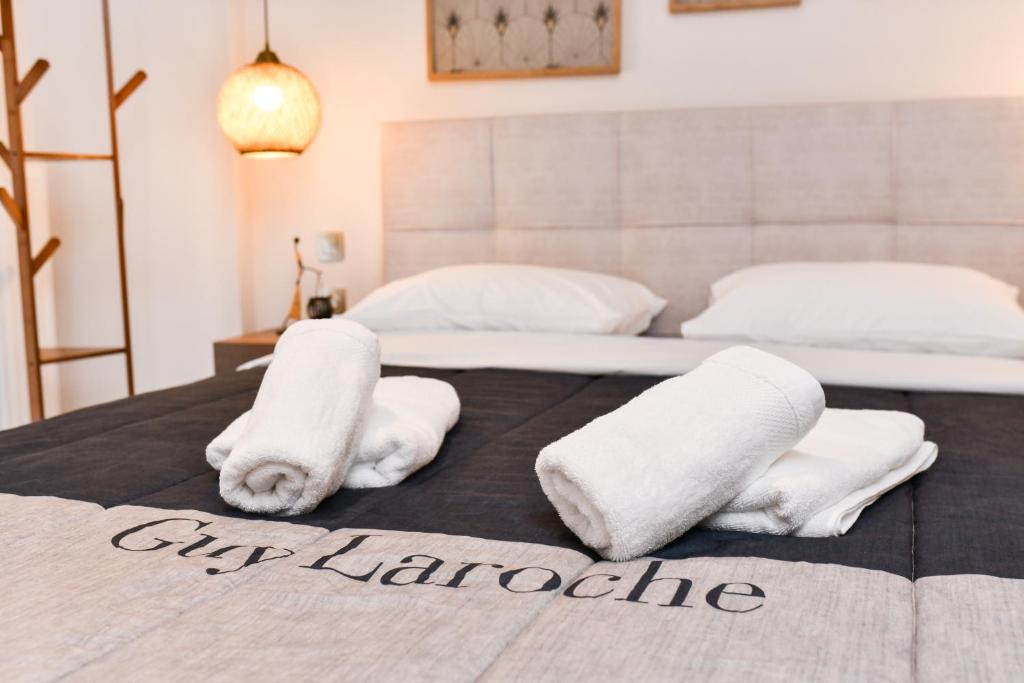 2 weiße Handtücher auf einem Bett mit 2 Betten in der Unterkunft Comfy Dots 2 in Larisa