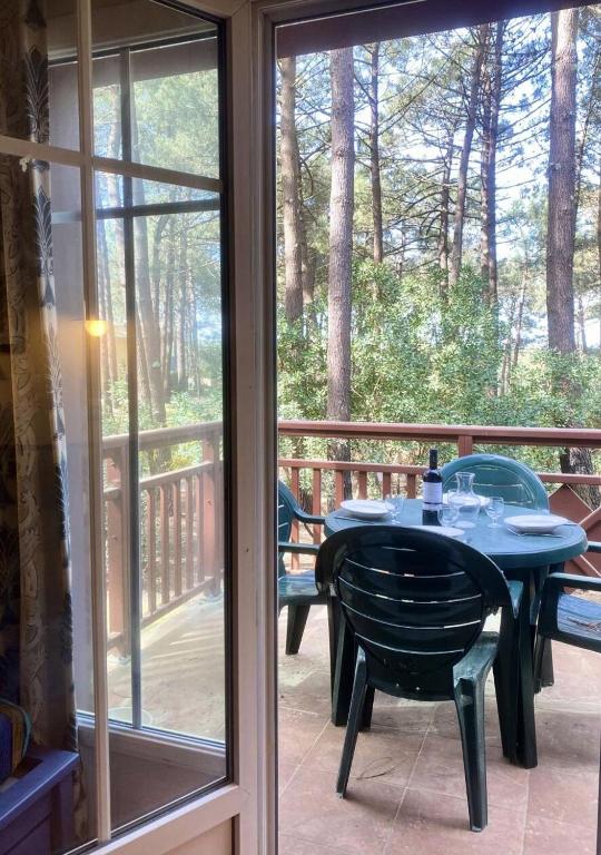 un patio avec une table et des chaises sur un porche dans l'établissement Résidence Lacanau Les Pins - 01416_ Appartement T2 avec balcon dans résidence avec piscine collective chauffée MAE-0841, à Lacanau