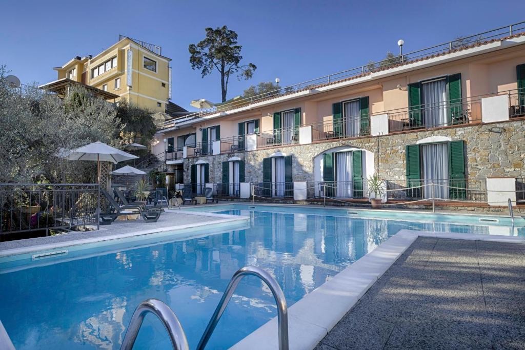 um hotel com piscina em frente a um edifício em Ulivo em Diano Marina