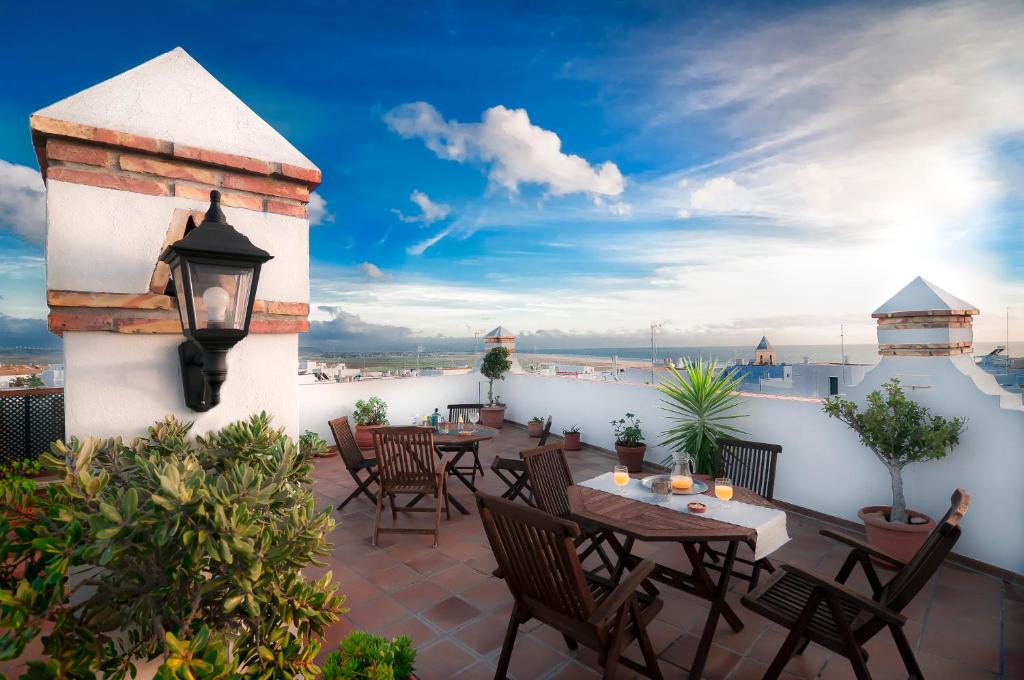 a patio with tables and chairs on a roof at Hotel Restaurante Blanco y Verde in Conil de la Frontera