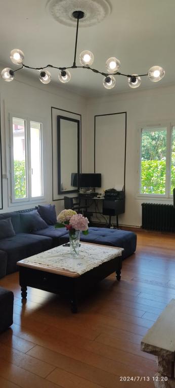 Una sala de estar con un sofá y una mesa de café. en Maison complete avec 5 chambres, en Montauban