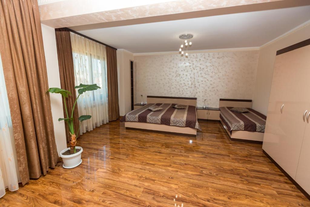 a bedroom with two beds and a potted plant at Hotel Kristal in Dospat