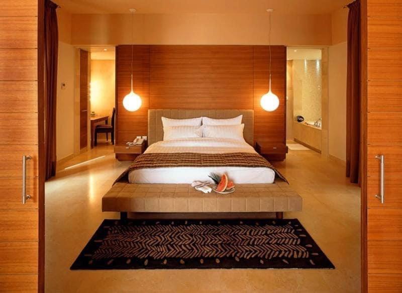 a bedroom with a large bed with a wooden headboard at Rum mona in Wadi Rum
