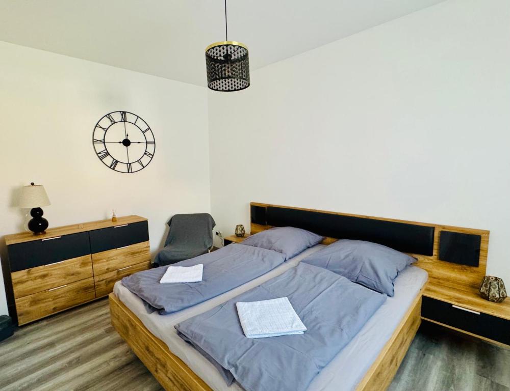 a bedroom with a bed and a clock on the wall at Ferienwohnung am Schloßgarten in Oranienbaum-Wörlitz