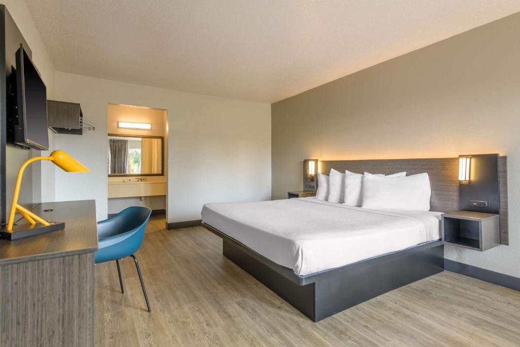 a hotel room with a bed and a desk and a chair at Motel 6-Spring Hill, FL - Weeki Wachee in Weeki Wachee
