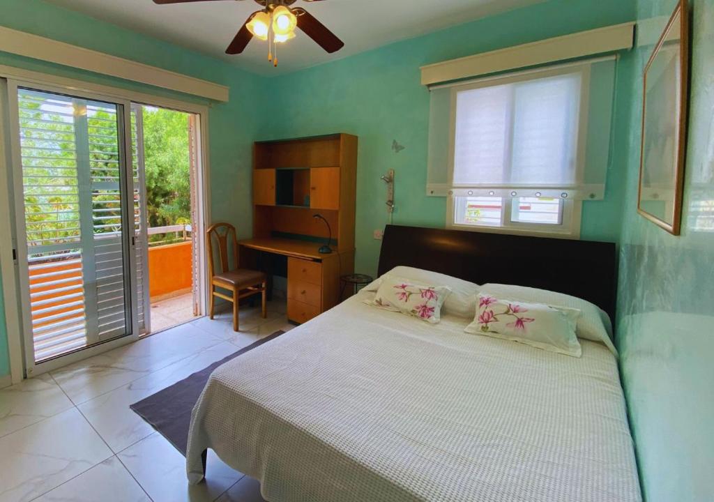 une chambre avec un lit, un bureau et des fenêtres dans l'établissement Villa Clementinka - 200 meters from the sea, à Klorakas