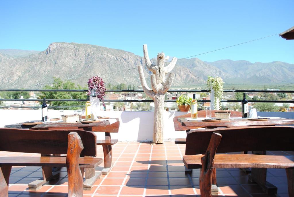 un patio con mesas y sillas y vistas a las montañas en Hostal Mirador del Valle en Cafayate