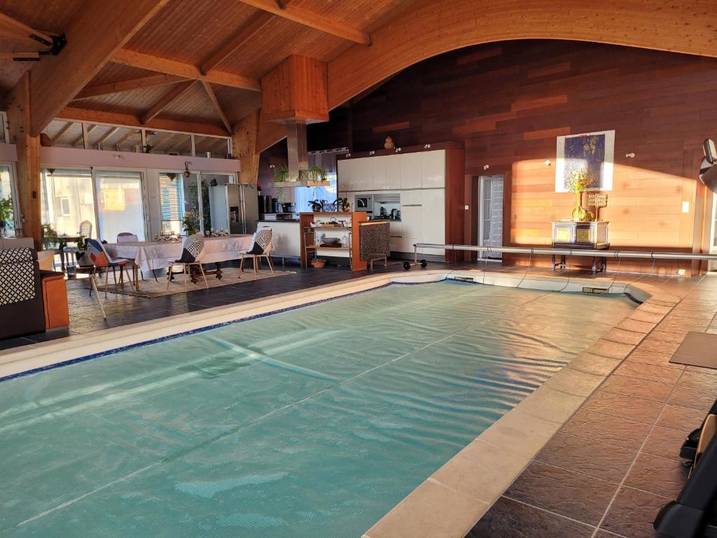 - une grande piscine dans une maison avec une cuisine dans l'établissement La Belle Demeure, à Aumagne