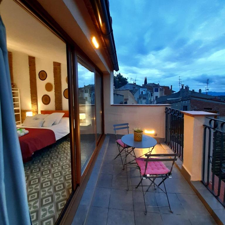 ein Balkon mit Bett, Tisch und Stühlen in der Unterkunft Cal Passió in Vimbodí