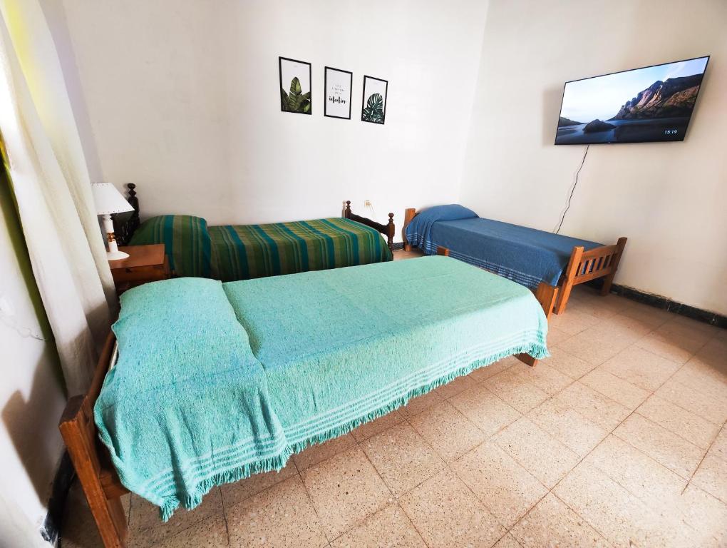 a bedroom with two beds and a tv on the wall at La casa de Angélica in Gualeguaychú