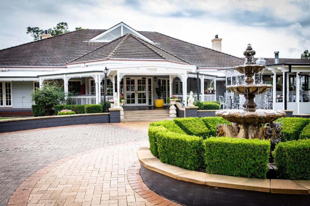 a fountain in the courtyard of a house at voco® Kirkton Park Hunter Valley by IHG in Pokolbin