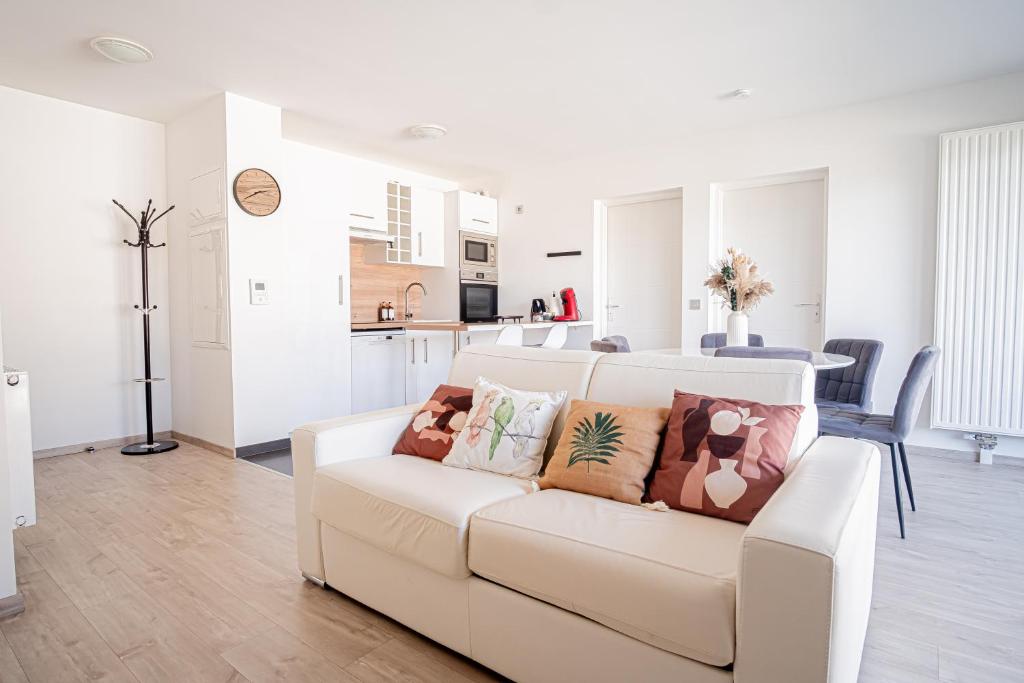 - un salon blanc avec un canapé blanc et des oreillers dans l'établissement Prestige Apartment & Cathedral View, à Reims