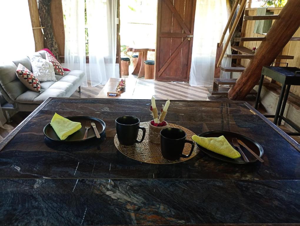 a table with cups and napkins on top of it at Cabaña lago Río Celeste in El Achiote